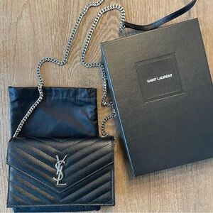 NEVER WORN WITH TAGS YSL Woc. Black with silver hardware.